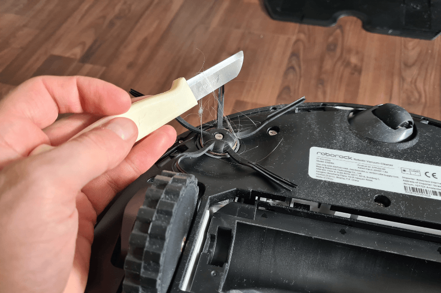 Волосы удаляются с боковой щетки Roborock S7 Pro Ultra с помощью ножа